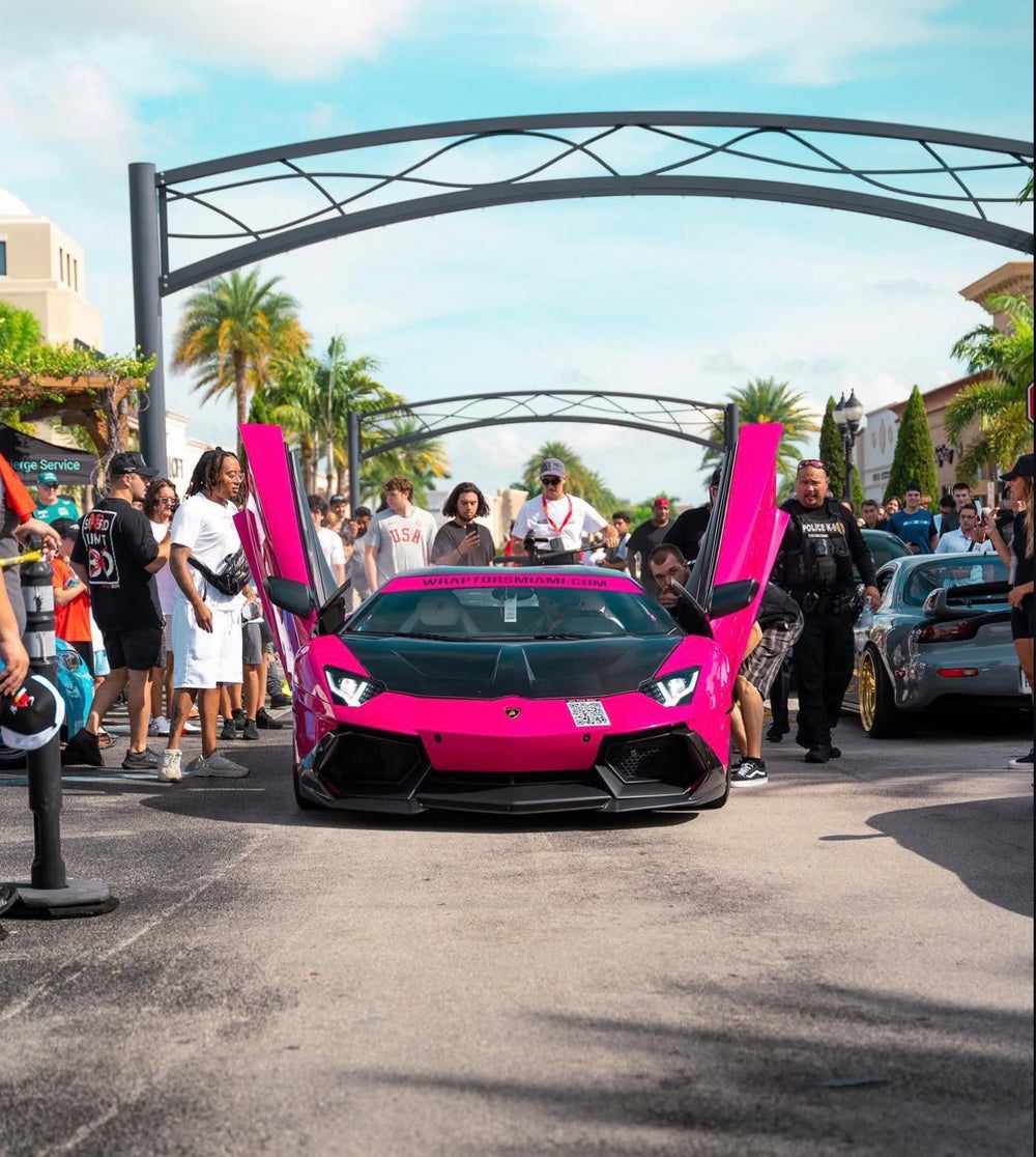 Bright pink Lamborghini Aventador with custom vehicle wrap displayed at exotic car event showcasing luxury car wrap and paint protection film installed by Wraptors Calgary