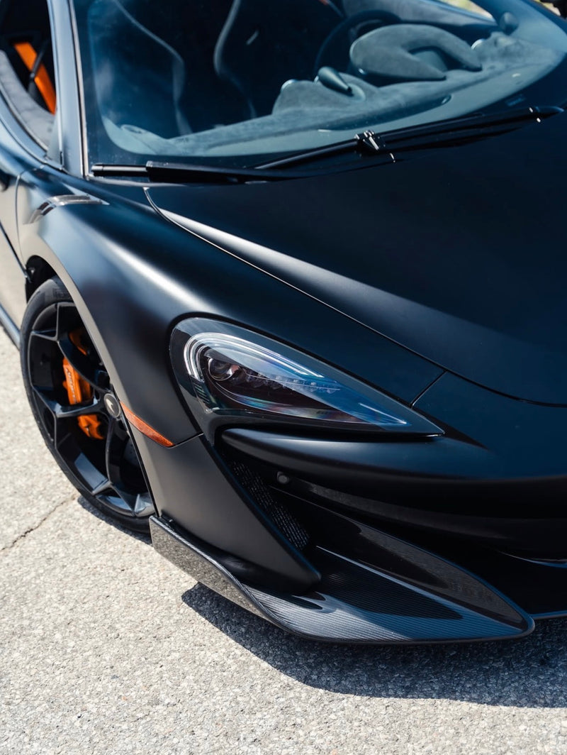 Close-up of a satin black mclaren front headlight and grille, wrapped in satin black coloured paint protection film and ceramic coating