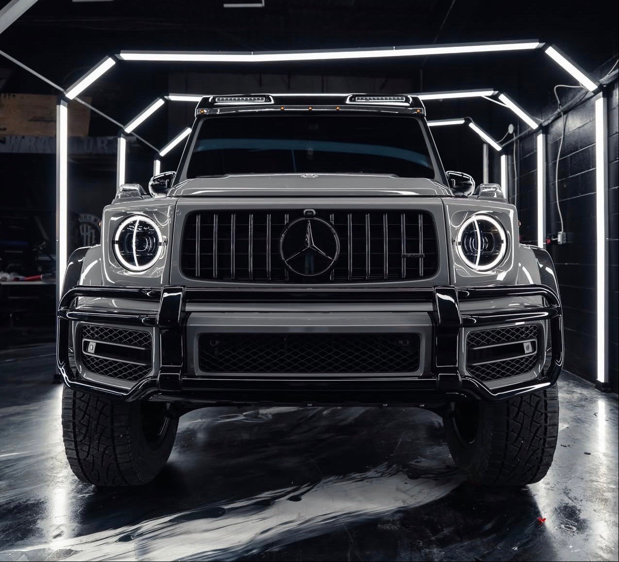Mercedes-Benz G-Class SUV wrapped gray with clear ppf in a dark setting with illuminated background